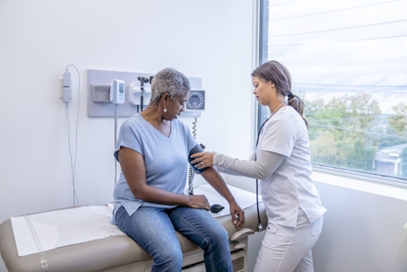 nurse taking senior female patient's blood pressure