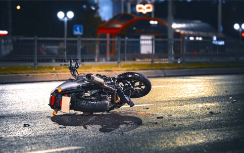 crashed motorcycle laying in the road at night