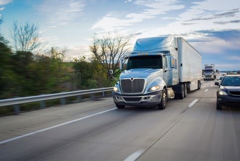 semi truck passing passenger car on freeway