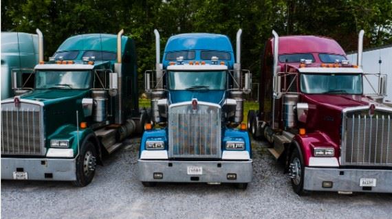three semi trucks parked in a row